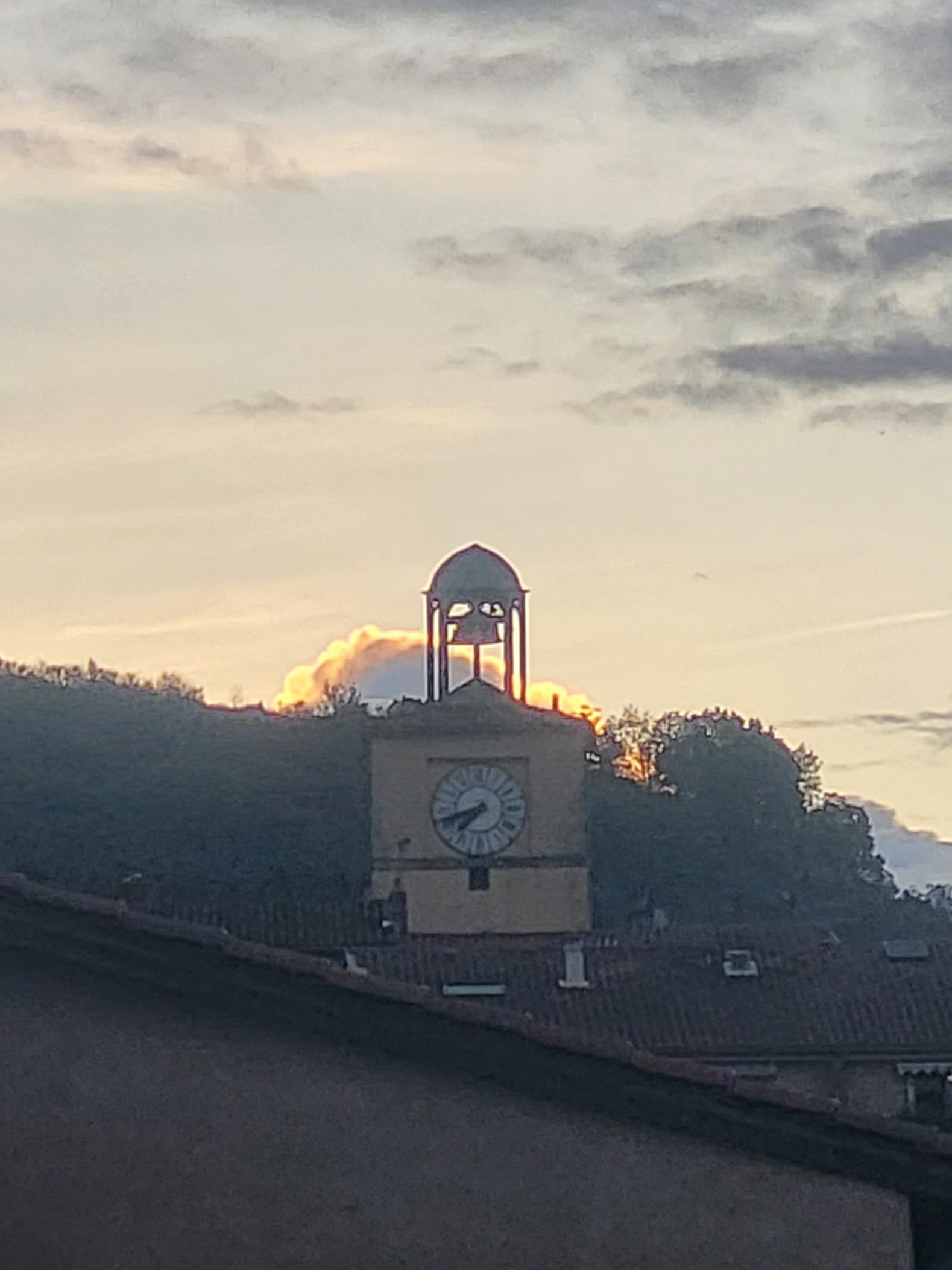 Clocher avec horloge de Vienne en Isère, au coucher du soleil, vu au-dessus des toits de la ville, illustrant le patrimoine local et l’environnement d’intervention d’un artisan ramoneur