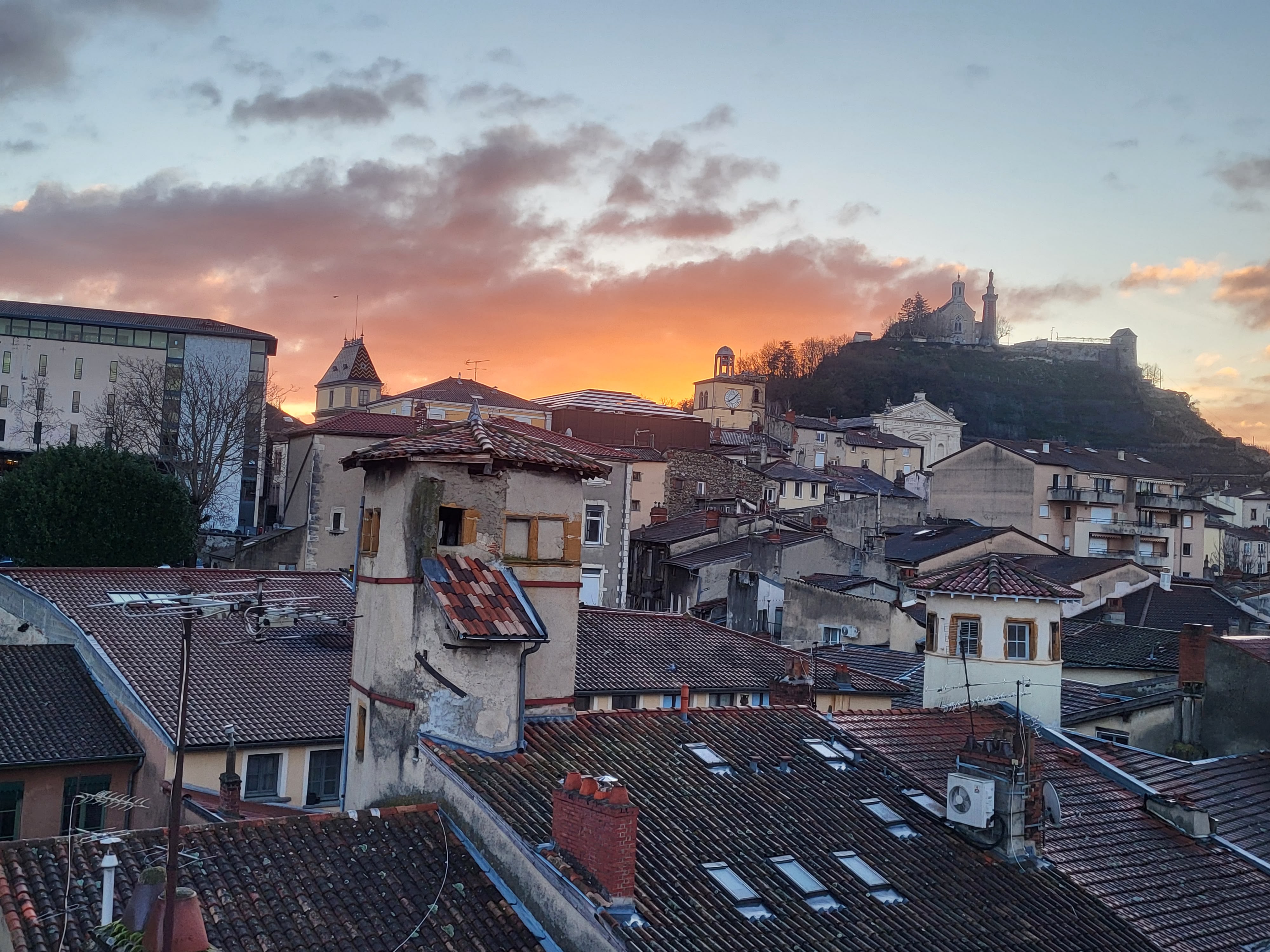 Panorama des toits de Vienne au coucher du soleil avec nombreuses cheminées. Vue sur la colline de pipet et la chapelle Notre Dame de Pipet